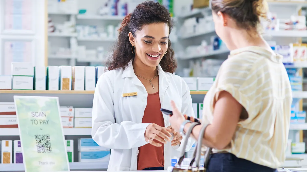 Young pharmacist assisting a customer