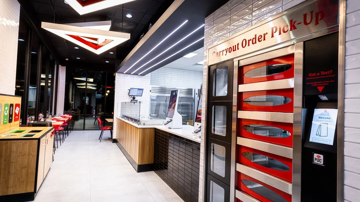 A store interior with white tile, red accents and pickup cabinets.