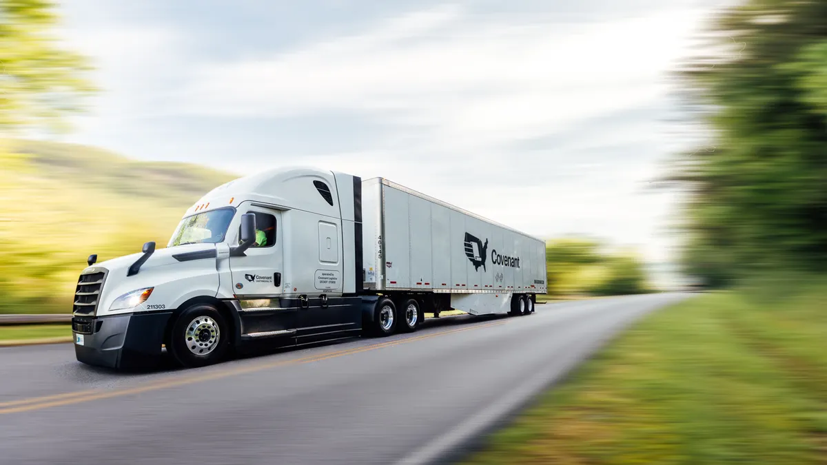 A moving freight truck on the road with a blurred background.