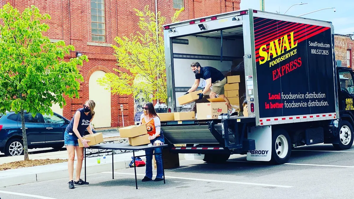 Saval Foodservice employee unloads boxes for donations to laid off restaurant employees