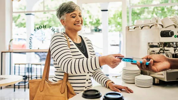 woman at a cafe for coffee buying breakfast with a credit card.