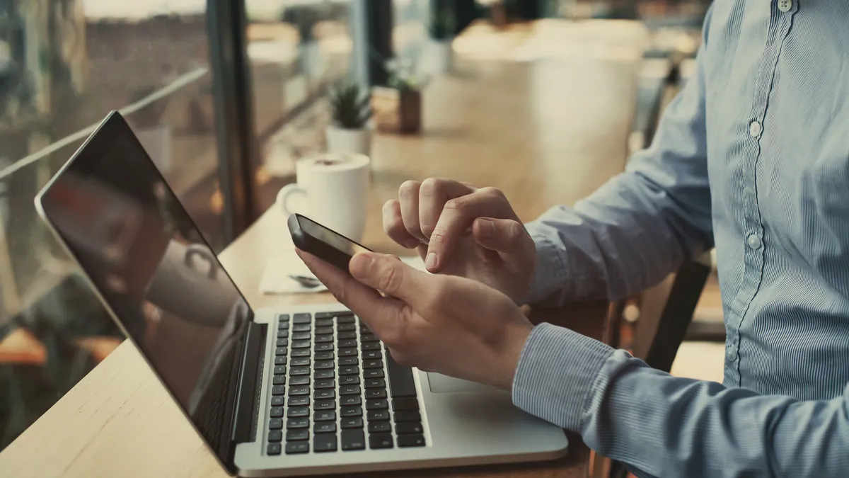 closeup of hands holding smartphone in cafe