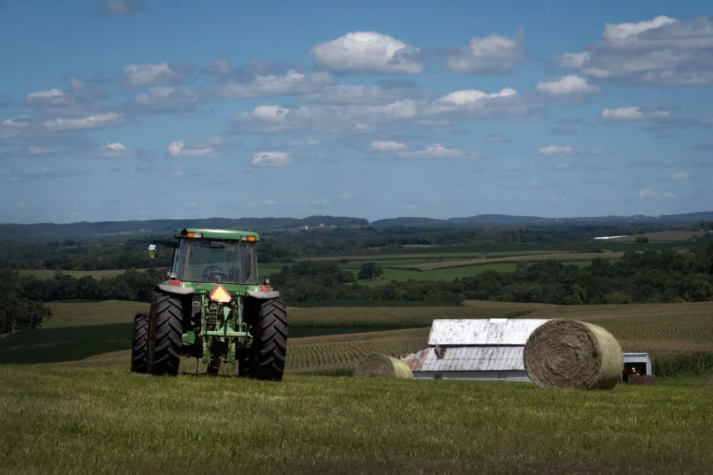 A tractor moves through a farm field