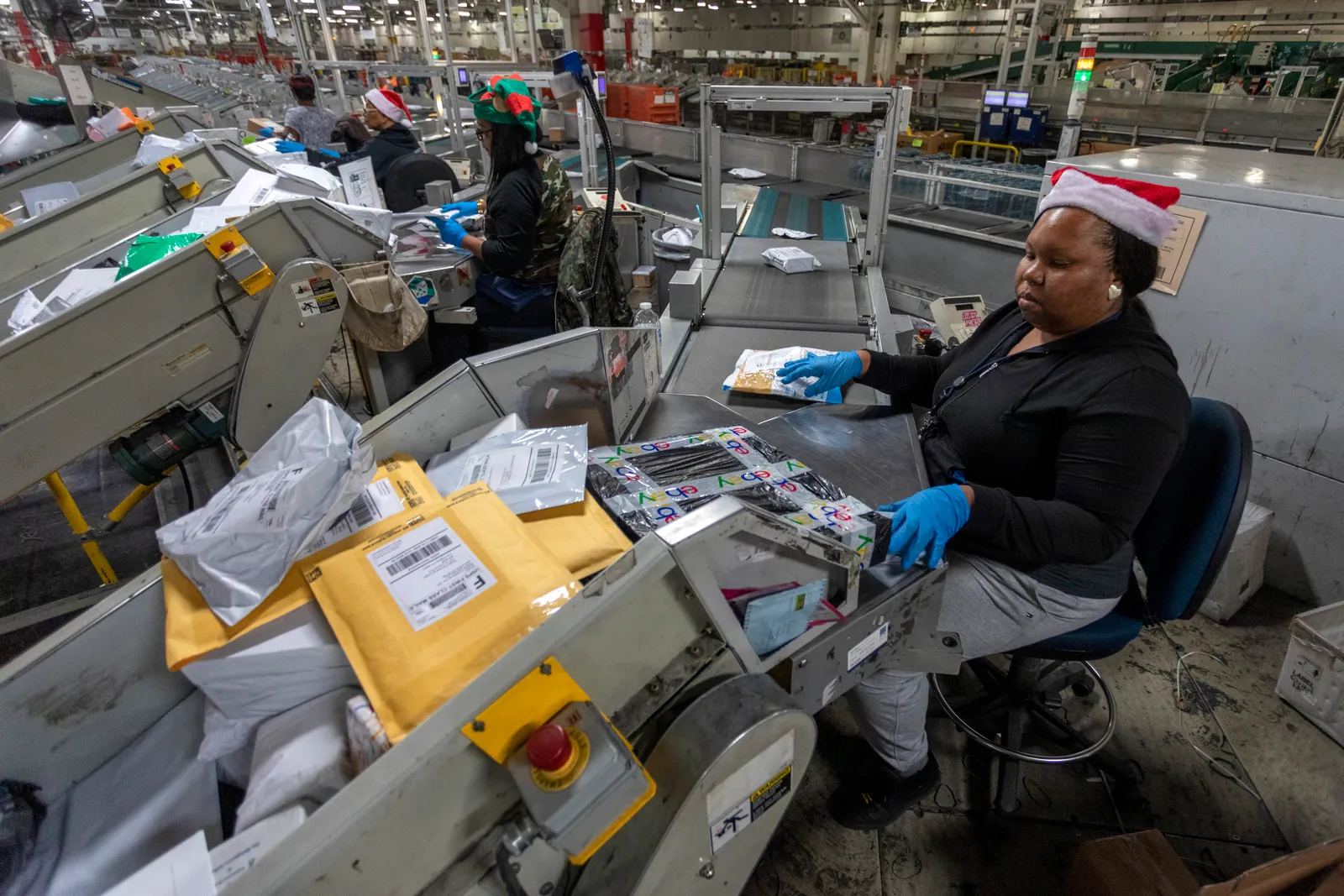 U.S. Postal Service workers scan parcels at the Los Angeles Processing and Distribution Center on Dec. 11, 2019.