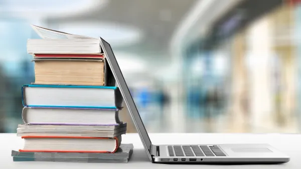 A picture of books next to a computer