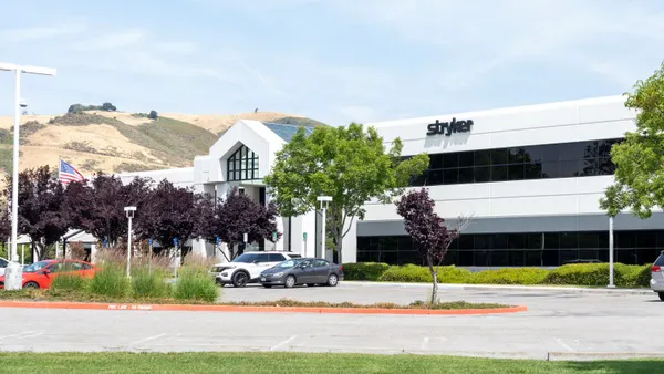 The Stryker logo is displayed on an office building with hills in the background.