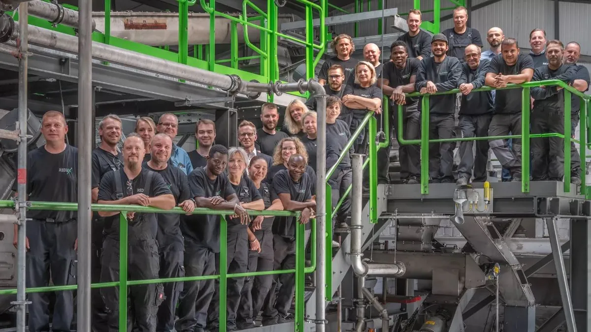 A group of workers at the Redux Recycling facility pose for a picture.