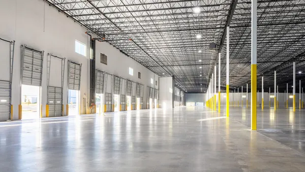 The interior of an industrial building, with bright lights and a fully white floor.