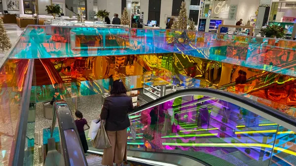 A person on an escalator inside a colorful building interior