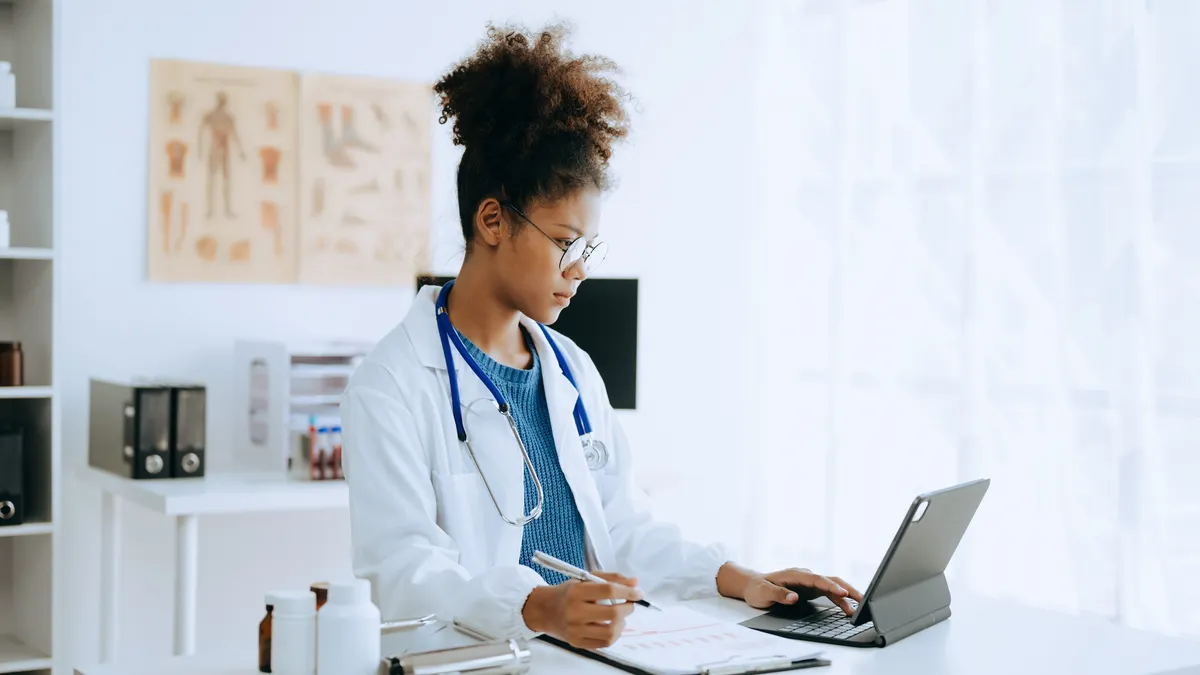 Doctor working with mobile phone and stethoscope in modern office.