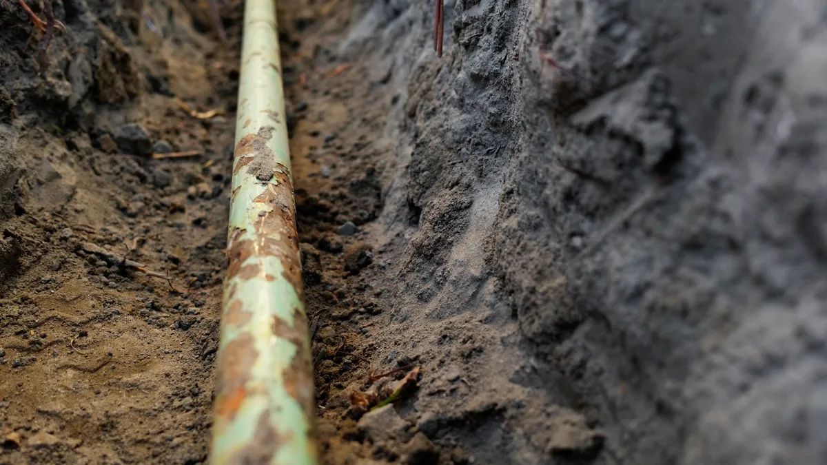 Close-up of a pipeline in a trench dug in the ground