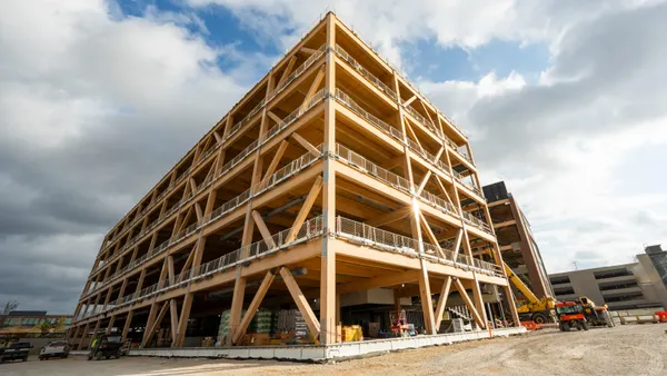 A wide shot of a tall mass timber framework on a cloudy day.