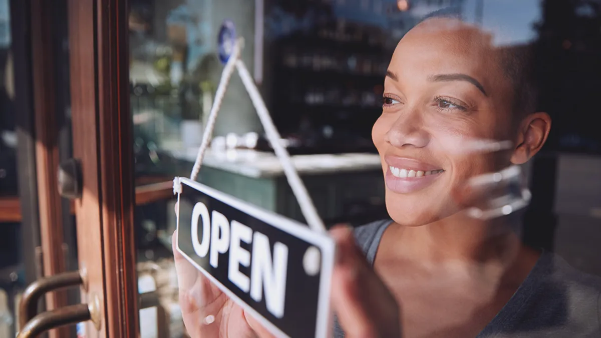 Store owner with open sign