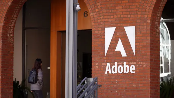 An Adobe sign appears on the brick facade of a building