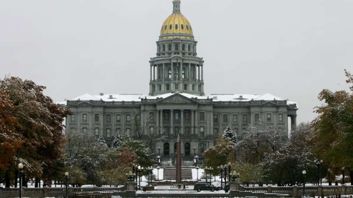Colorado State Capitol Building stands across a snow covered Civic Center Park