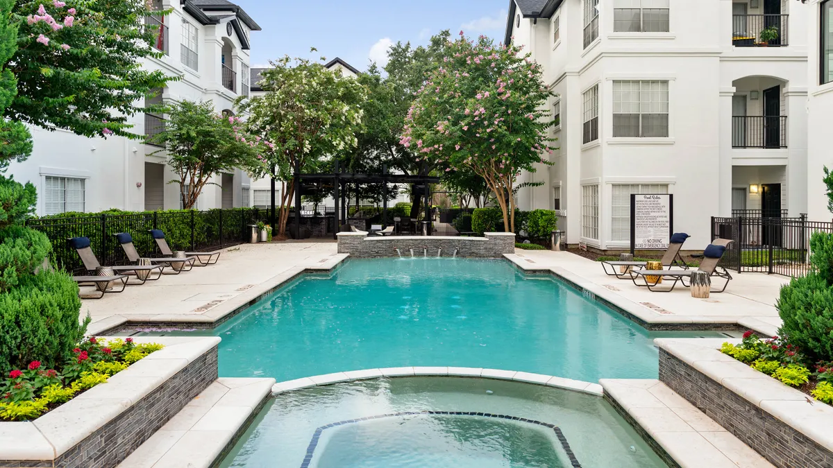 white apartment buildings surrounding a pool