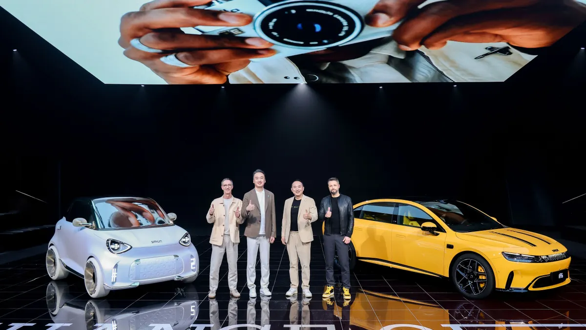 Smart Automobile Co. executives post next to a white and yellow vehicle during an event in Beijing, China.