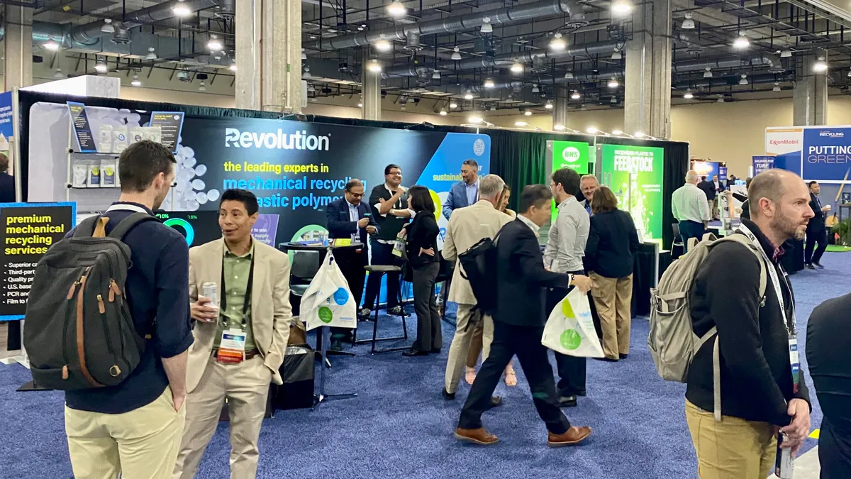 People walk by displays at a trade show