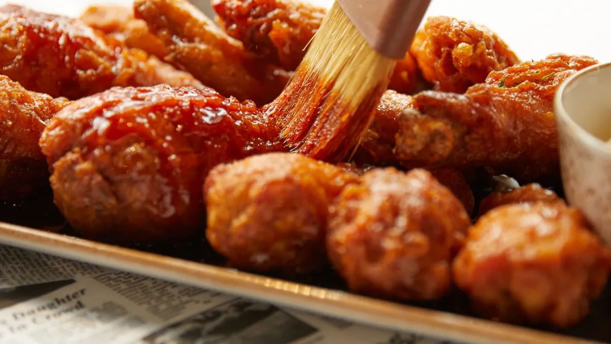 Sauce being brushed on fried chicken