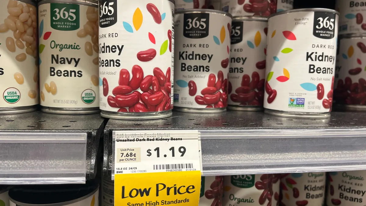 Canned goods at Whole Foods marked as discounted by a yellow tag that reads "Low Price"