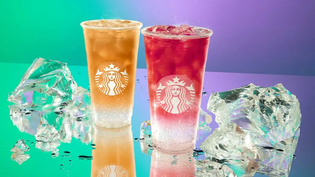 Two Starbucks Iced Energy drinks nearby shattered ice cubes.