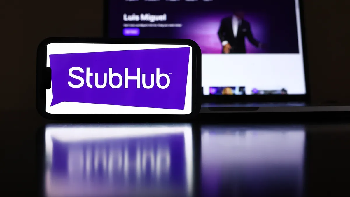 The StubHub logo and webpage are displayed on a cell phone and computer monitor.