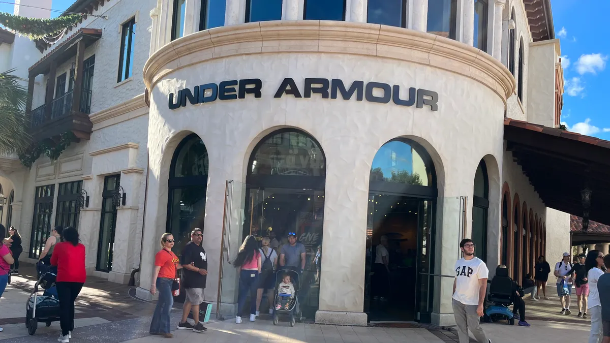 Shoppers walking by an Under Armour store.