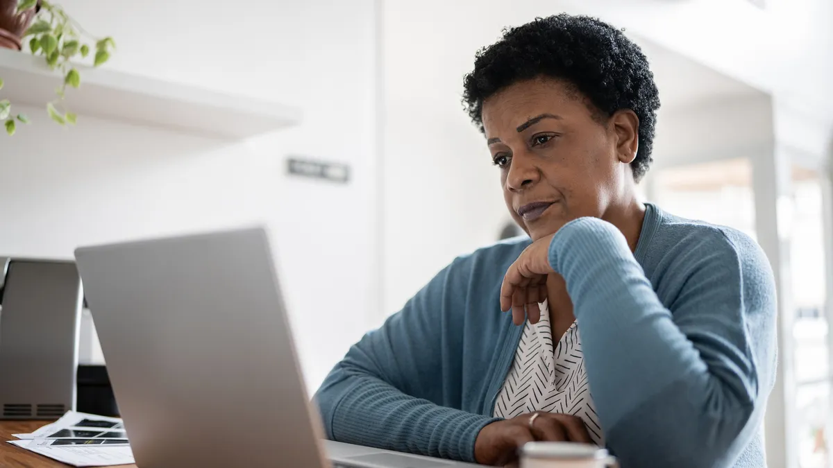 A serious, middle-aged or senior Black person works from home