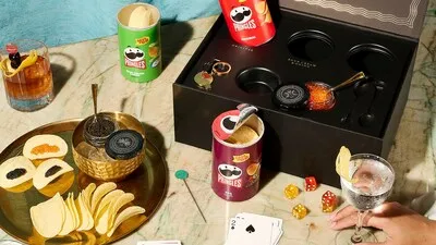 A table display of open Pringles chip cans and opened caviar containers