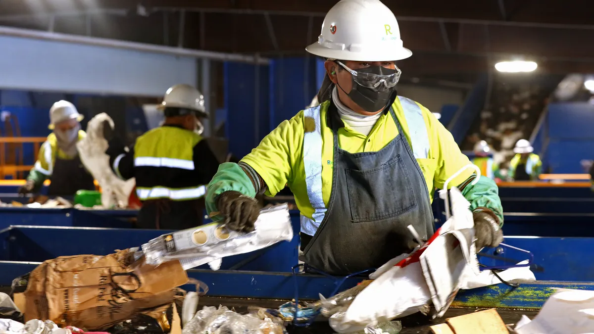 A worker sorts paper at a MRF