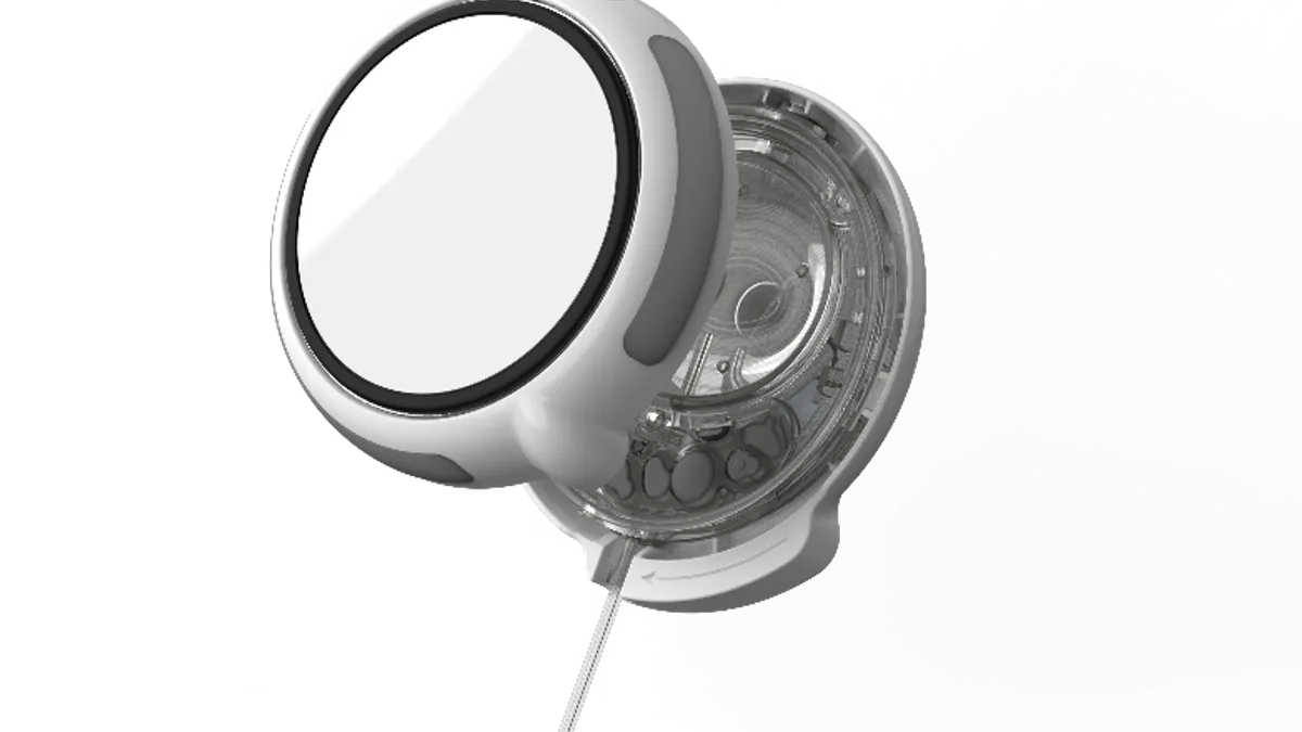 A white, rounded device is open showing clear tubing inside.