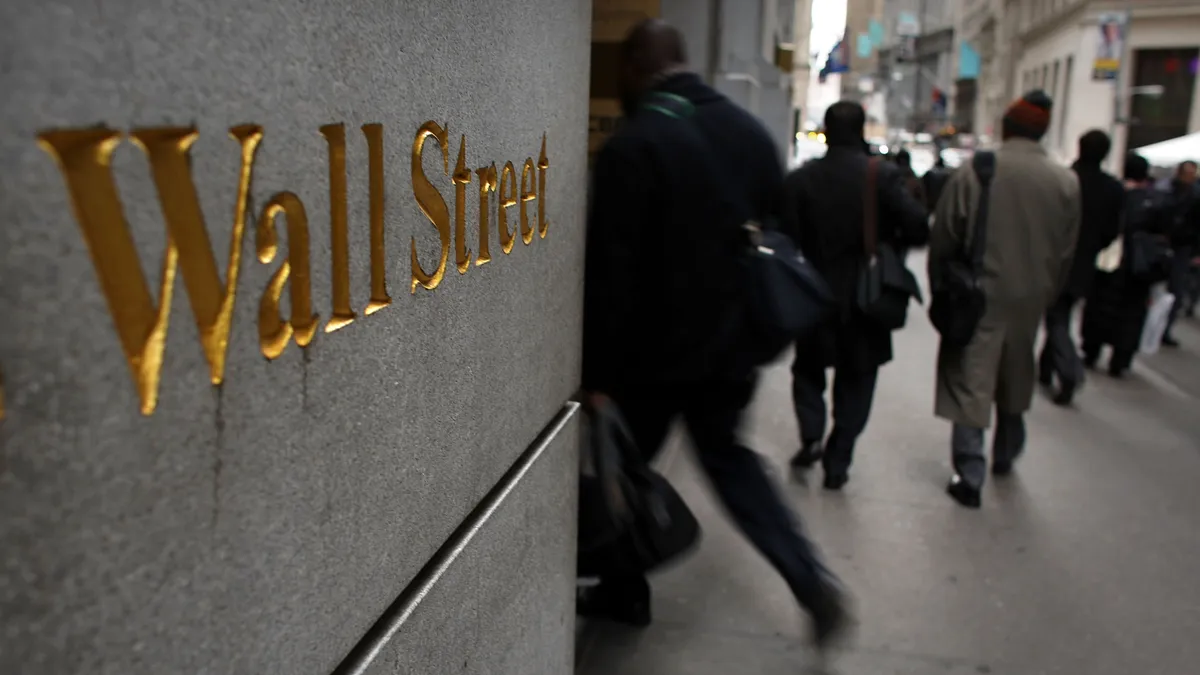 A building wall engraved with the words Wall Street.