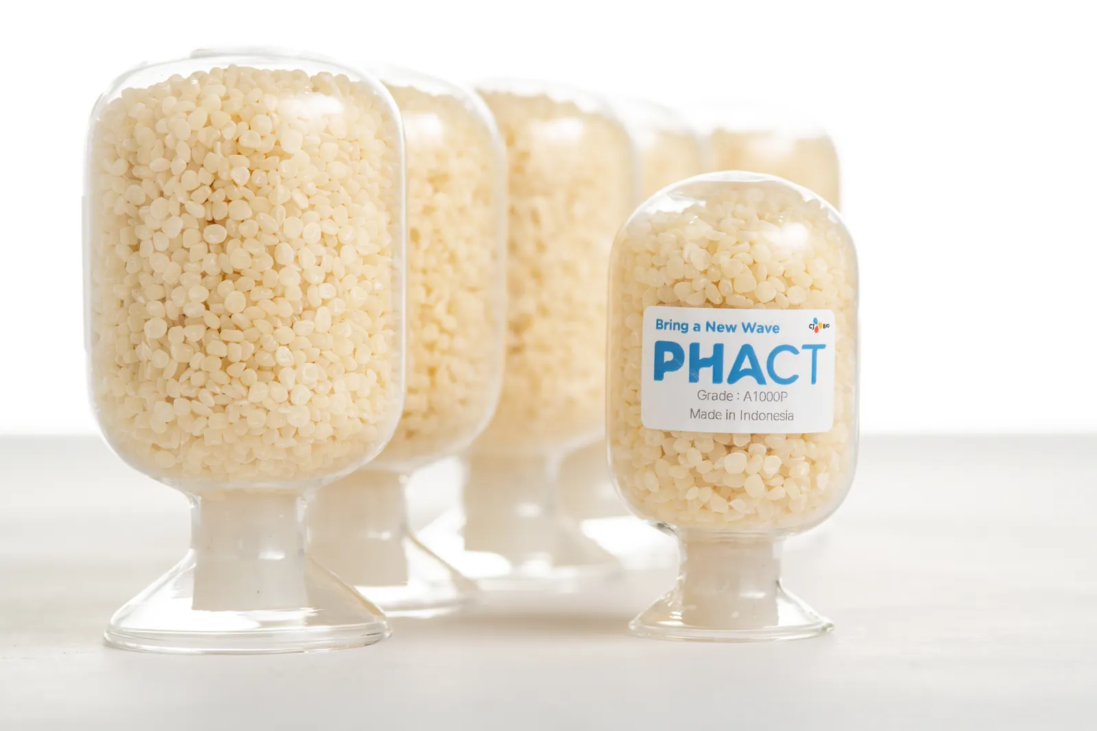 A closeup view of a container holding bioplastic pellets, with the PHACT label