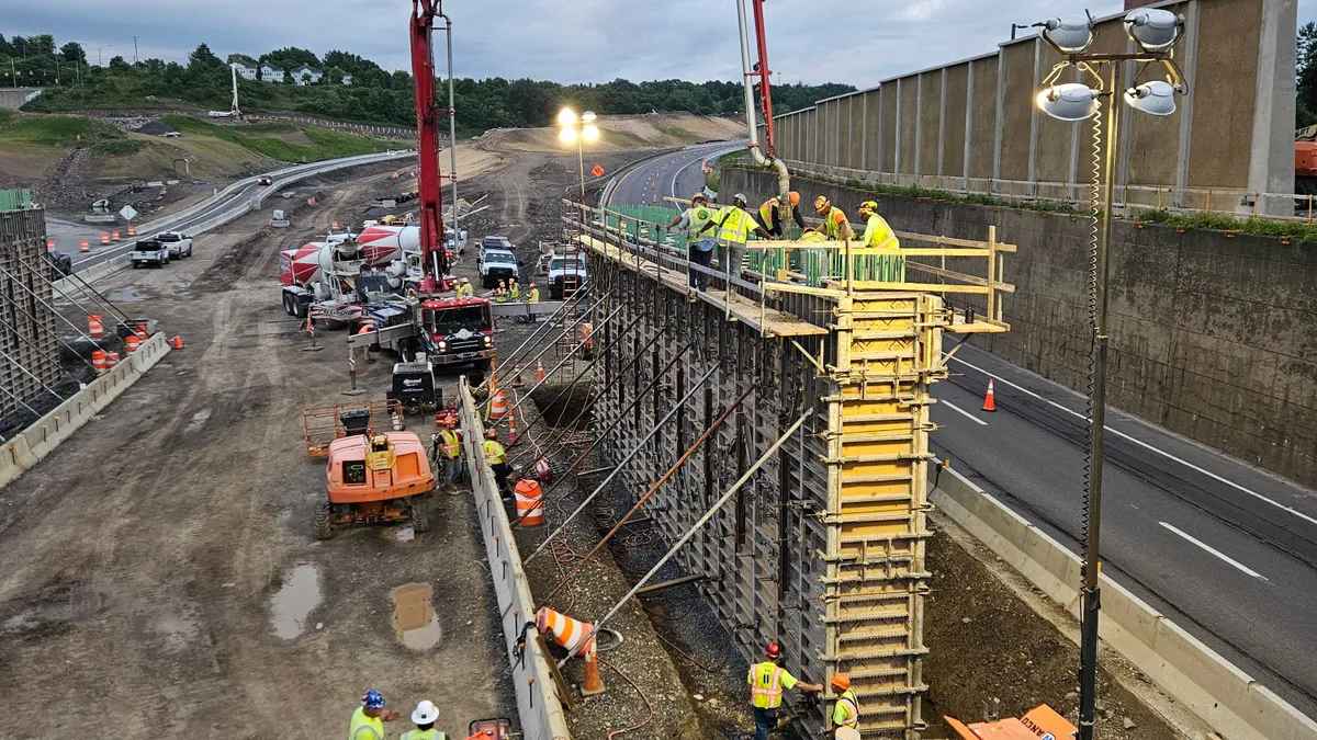 Crews placing concrete for the west abutment on the relocated East Glen Ave. bridge, near Loretto & Brighton Towers, crossing future Business Loop 81.