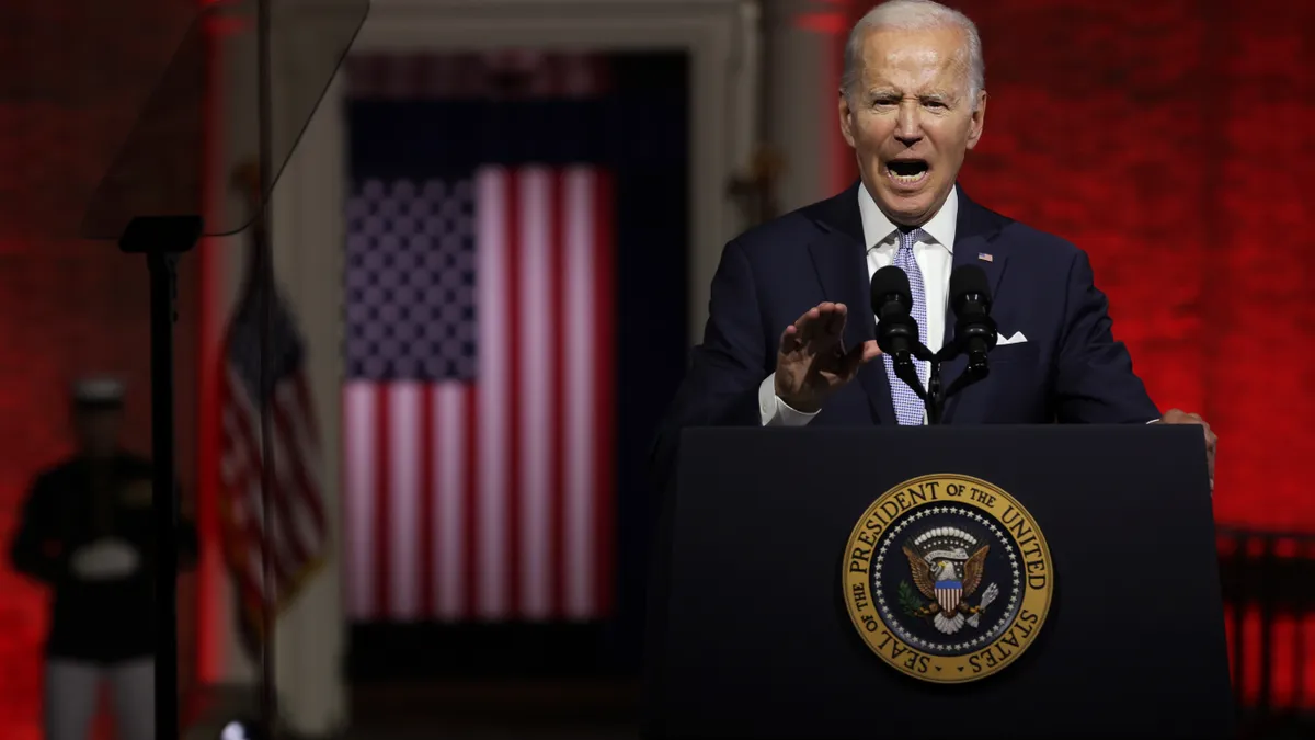 President Joe Biden speaks at a podium.