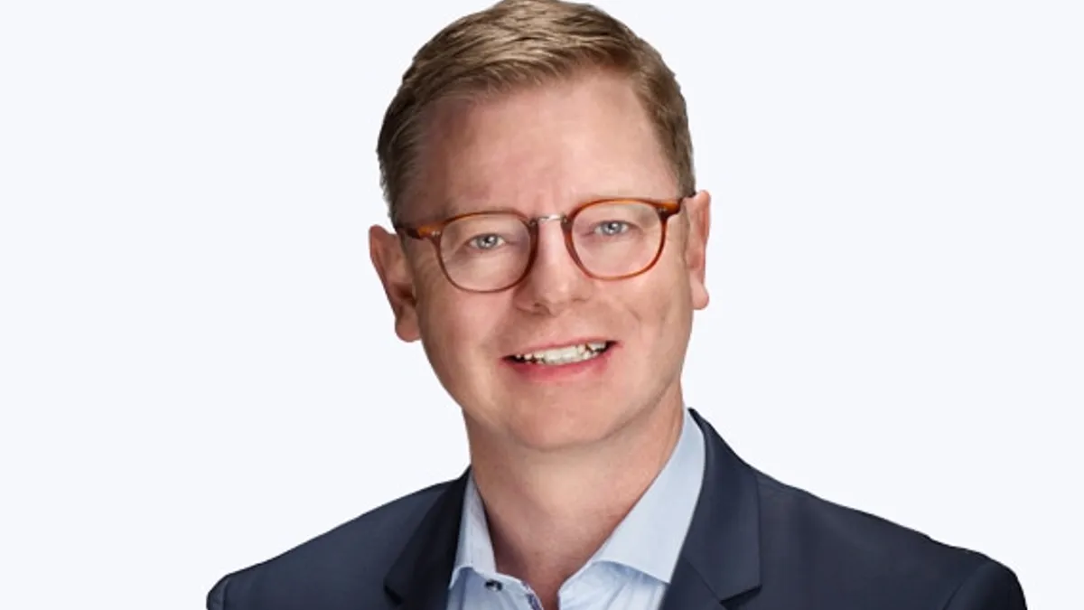 A headshot of Agilent CEO-elect Padraig McDonnell wearing a blue suit jacket.