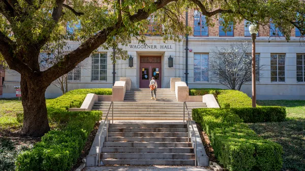 A student walks into a campus building at UT-Austin.