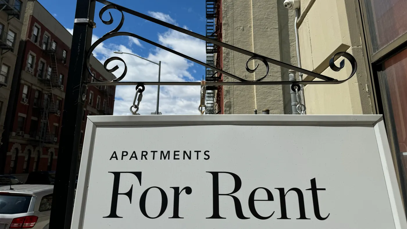 "Apartments for Rent" sign hanging from a residential building in Harlem, New York City.