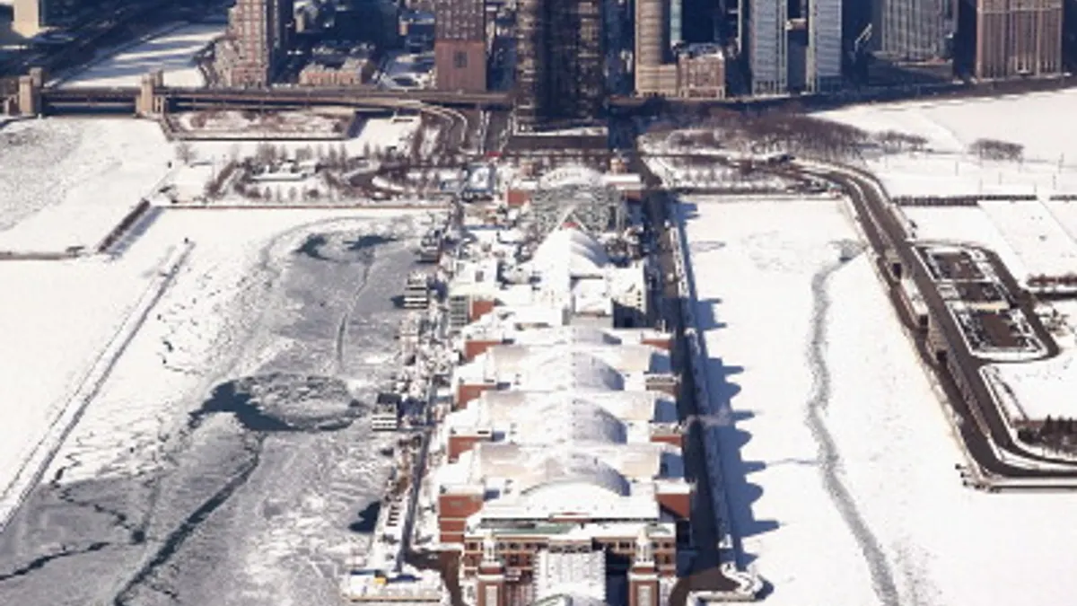 aerial photo of Chicago's Navy pier during the winter extending into frozen lake in forefront with skyline in background