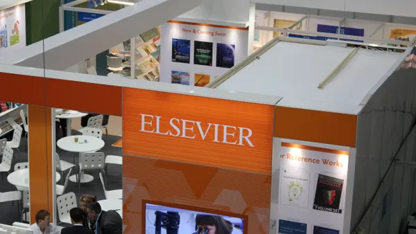 A bird's eye view of an academic convention, focusing on an orange display booth with signage reading "Elsevier."