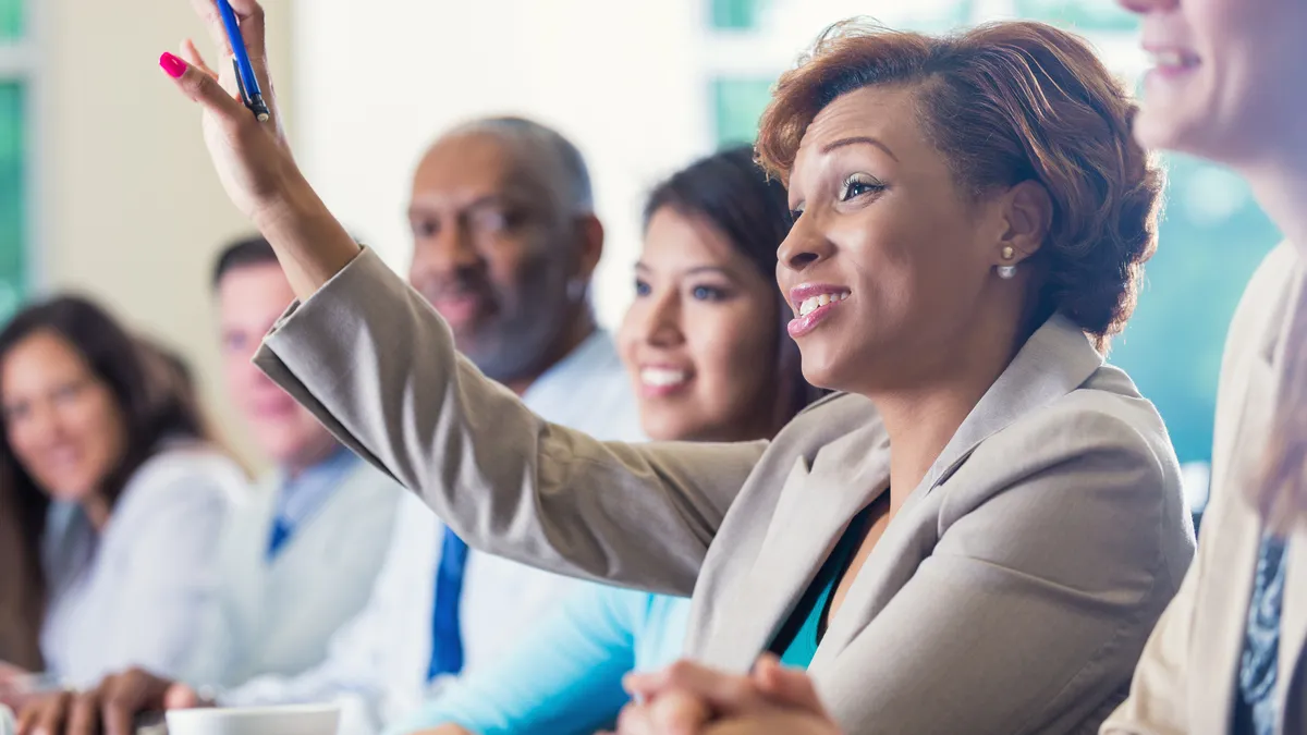 African American businesswoman raising hand, asking question in business conference