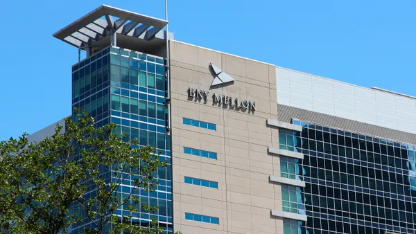 A building bearing BNY Mellon logo against a clear blue sky