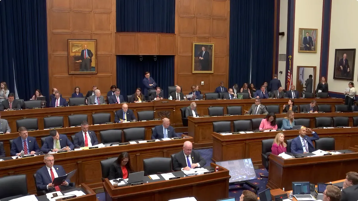 A wide view of a hearing room in the U.S. Capitol with members of Congress and staffers.
