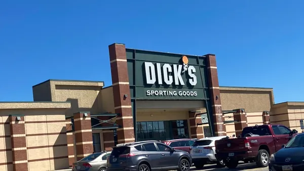 Cars parked in front of a sporting goods store.