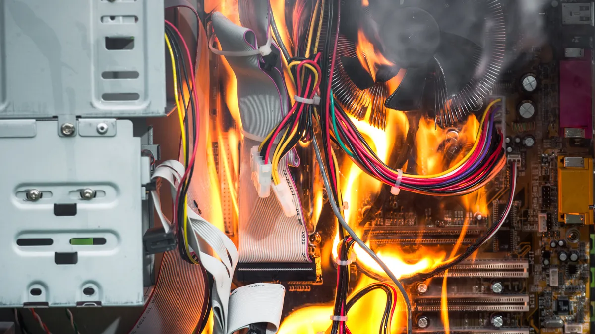 Fire destroying the motherboard and components of a desktop PC.