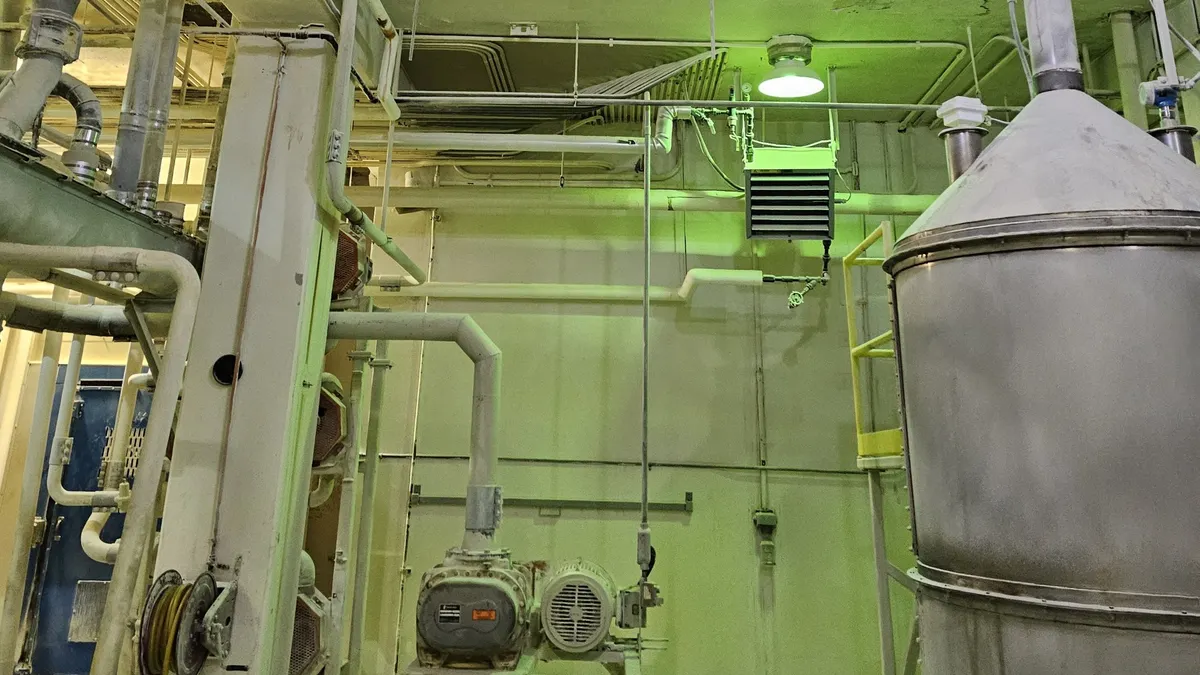 industrial interior, complex pipe system, metal tank, green lighting, dusty atmosphere