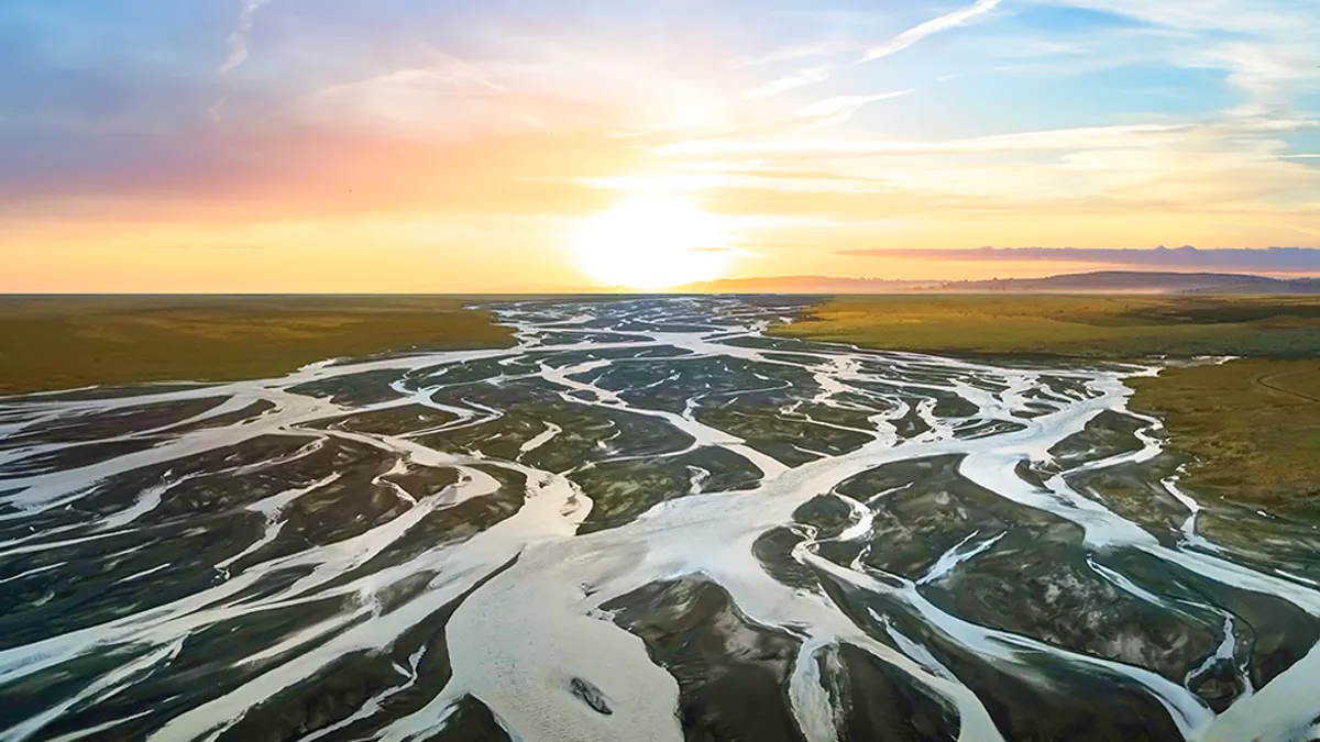 A watershed of rivers beneath a sunrise.