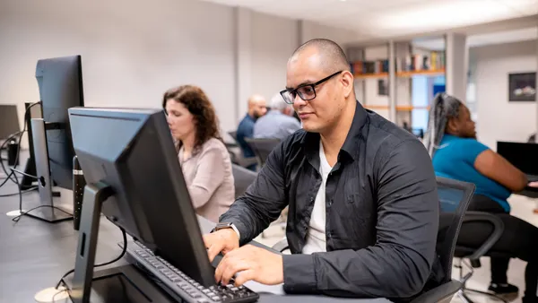 Individuals work on computers.