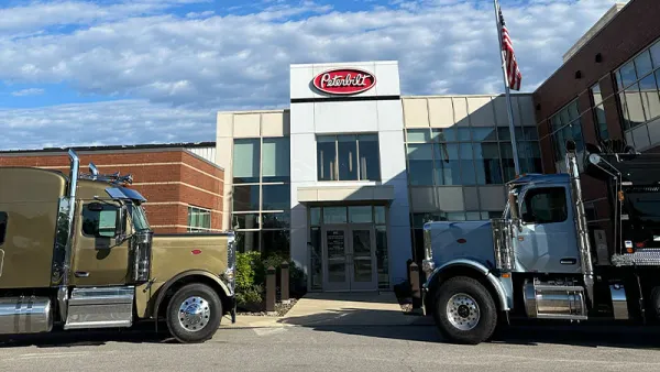Ohio Peterbilt's headquarters with two trucks parked in the front of the building.