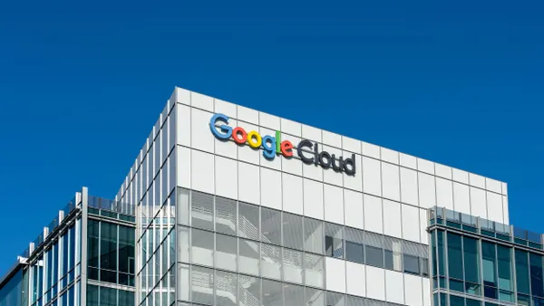 A close-up view of a modern glass and metal checkered facade building with a logo that reads, "Google Cloud." 
